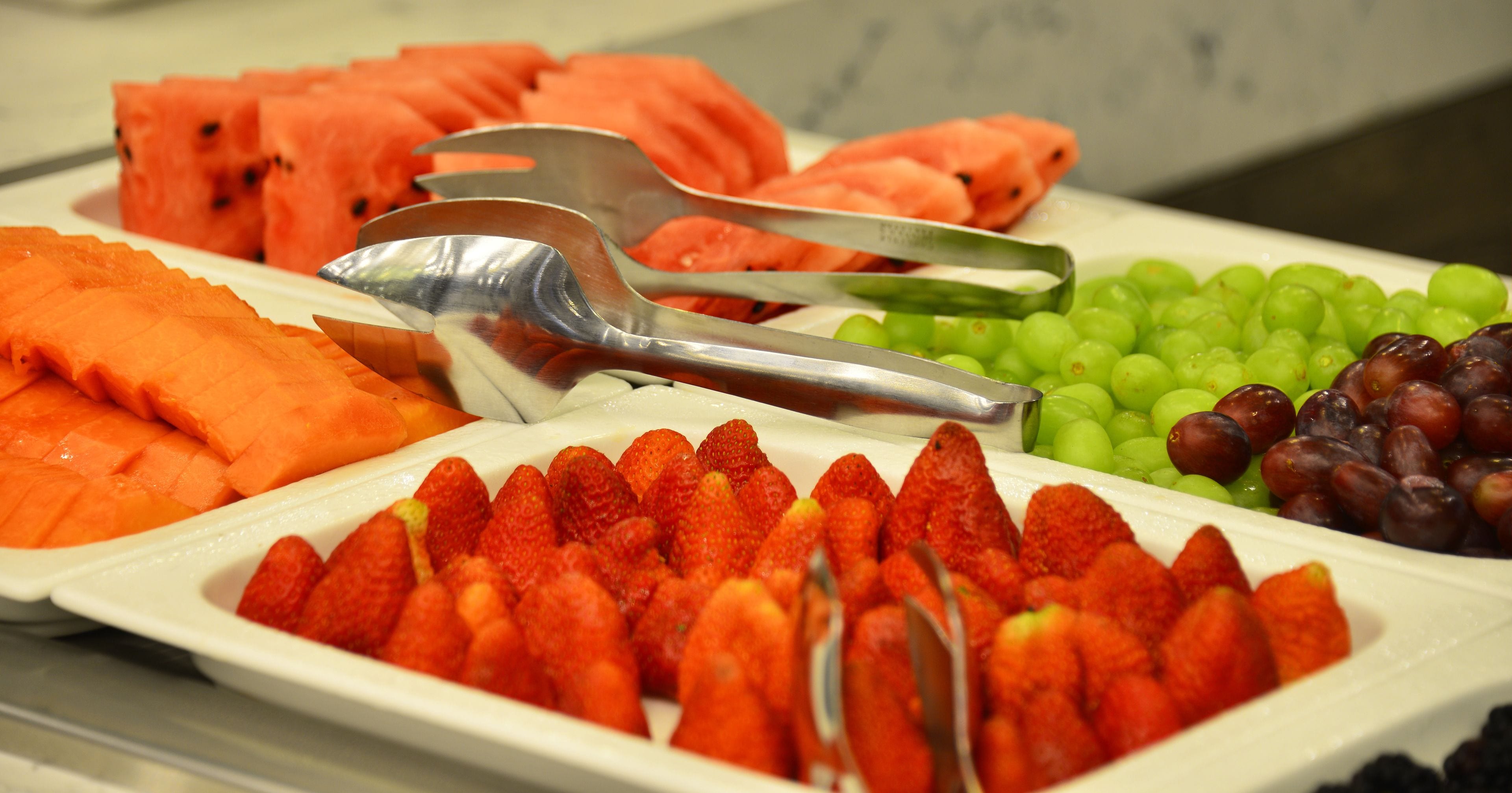 Un vassoio di frutta con anguria, uva e fragole.