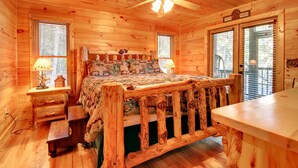 A cozy log cabin bedroom with a wooden bed, two bedside tables, a ceiling fan, and a sign reading "Winter Wonderland". - Crockett Mountain Lodge Nevaeh Cabin Rentals (Blue Ridge)