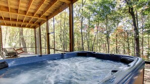 A hot tub in a wooden cabin with a forest view. - SERENITY WOODS Apartment 3 NEVAEH CABIN RENTALS (Mineral Bluff)