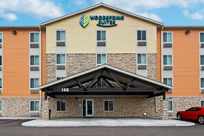 A multi-story hotel with a stone facade and a flat roof. - WoodSpring Suites Reno Sparks (Sparks)