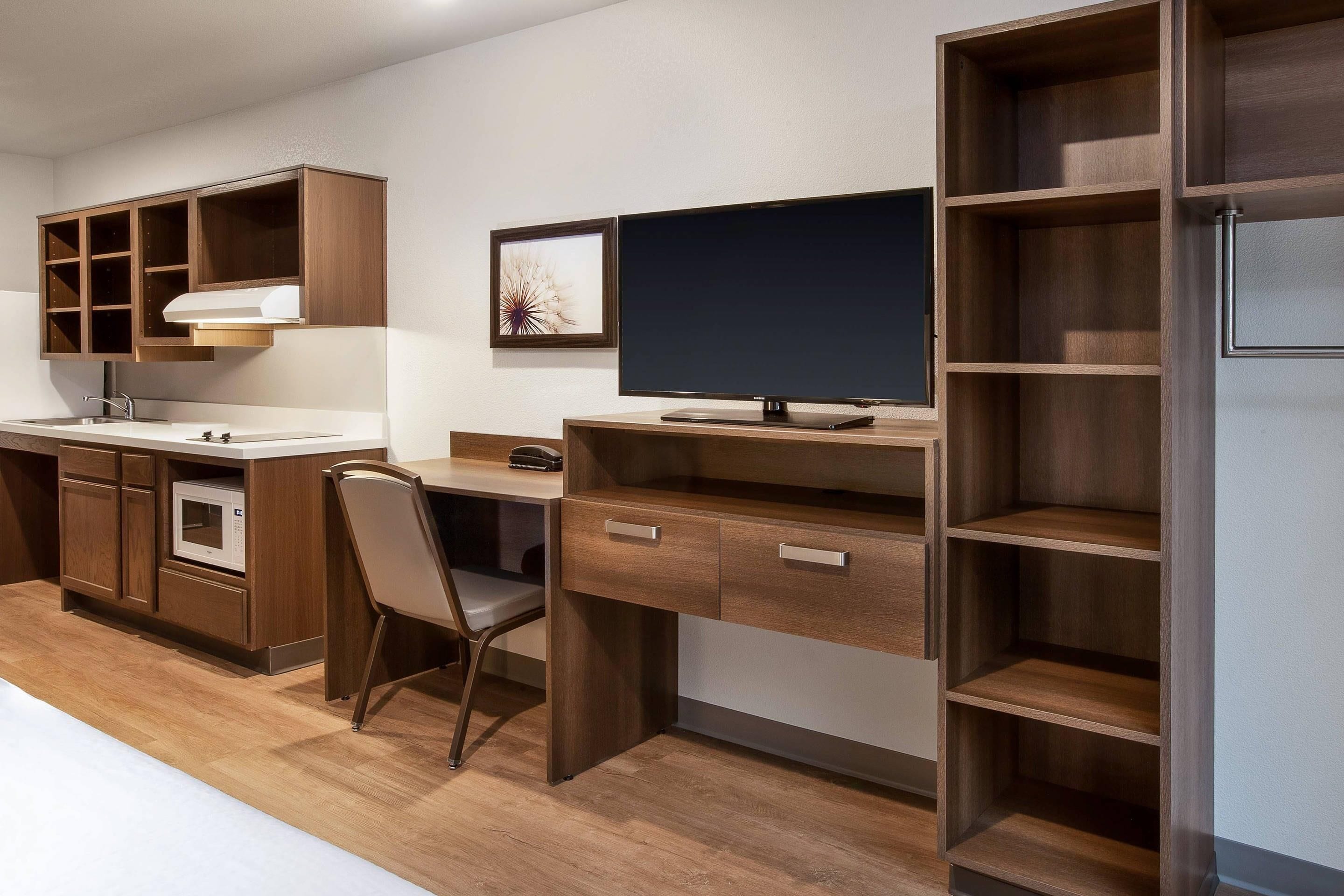 A kitchenette with a built-in oven, a sink, and a microwave.