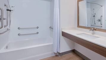 A modern bathroom with a bathtub, shower, and vanity.