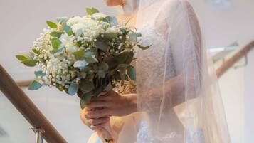 Bride stands on a staircase with a glass railing, surrounded by elegant details.