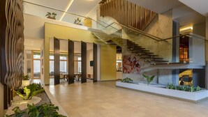 A spacious lobby with a modern staircase, a seating area, and a decorative wall. - Hyatt Centric San Salvador (Antiguo Cuscatlán)