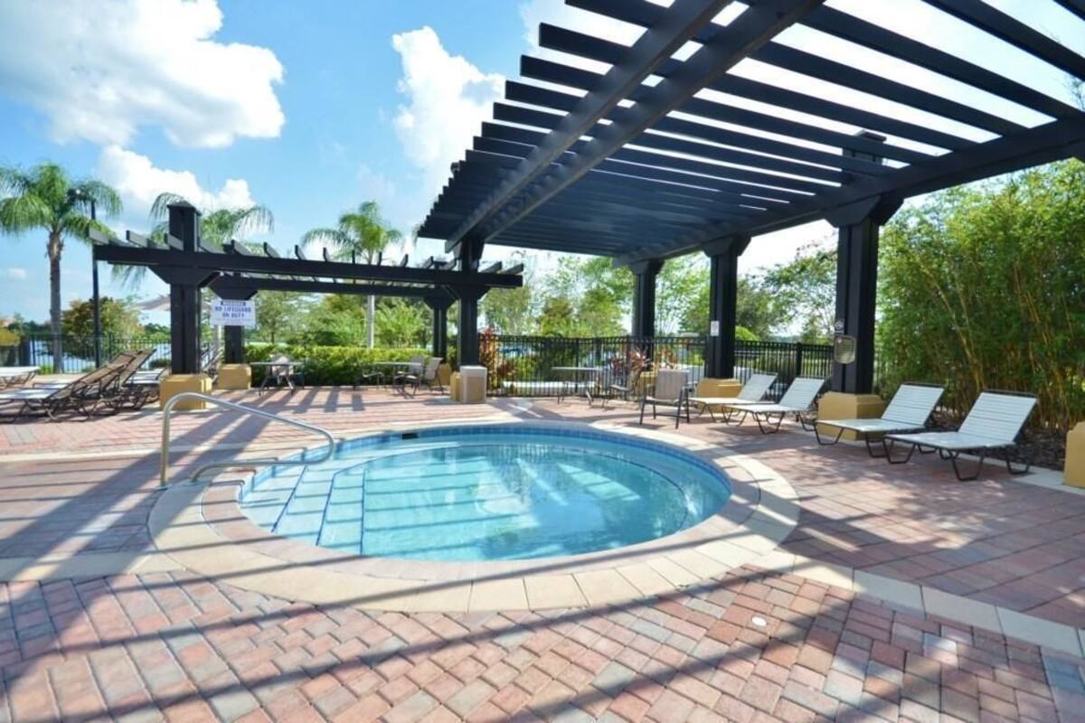 A pool area with a covered section, lounge chairs, and a sign indicating a 50% discount.