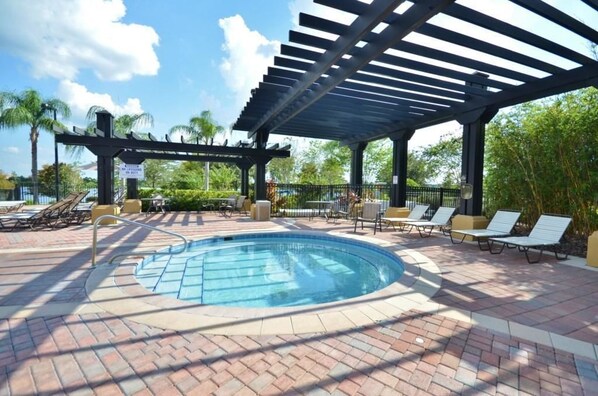 A pool area with a covered section, lounge chairs, and a sign indicating a 50% discount.