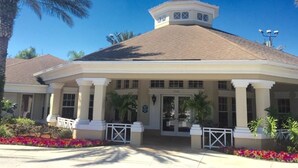 A two-story building with a flat roof, a covered entrance with columns, and a small tower-like structure on top. - Windsor Palms Resort (Kissimmee)