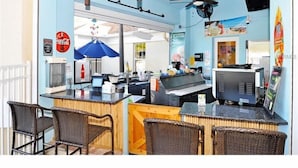 A restaurant with a counter, chairs, ceiling fans, and a Coca-Cola sign. - Windsor Palms Resort (Kissimmee)