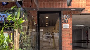 A building entrance with a glass door, a brick facade, and a sign indicating '93B 30'.