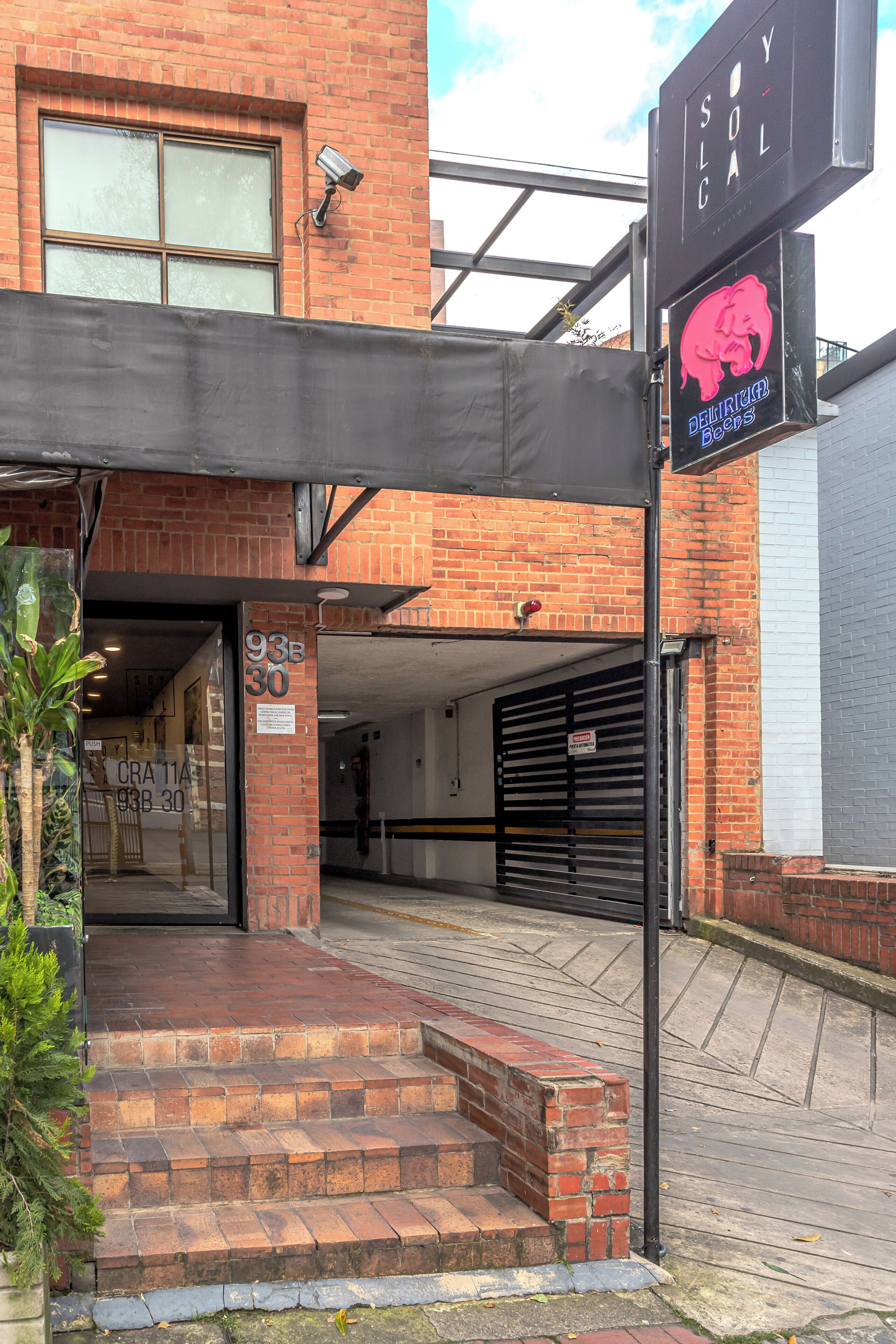 Un edificio de ladrillo con un porche cubierto, una puerta de garaje y un letrero que dice 'Detroit Dogs'.