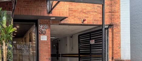 A brick building with a covered entrance, a garage door, and a sign for 'Detroit Dogs.'