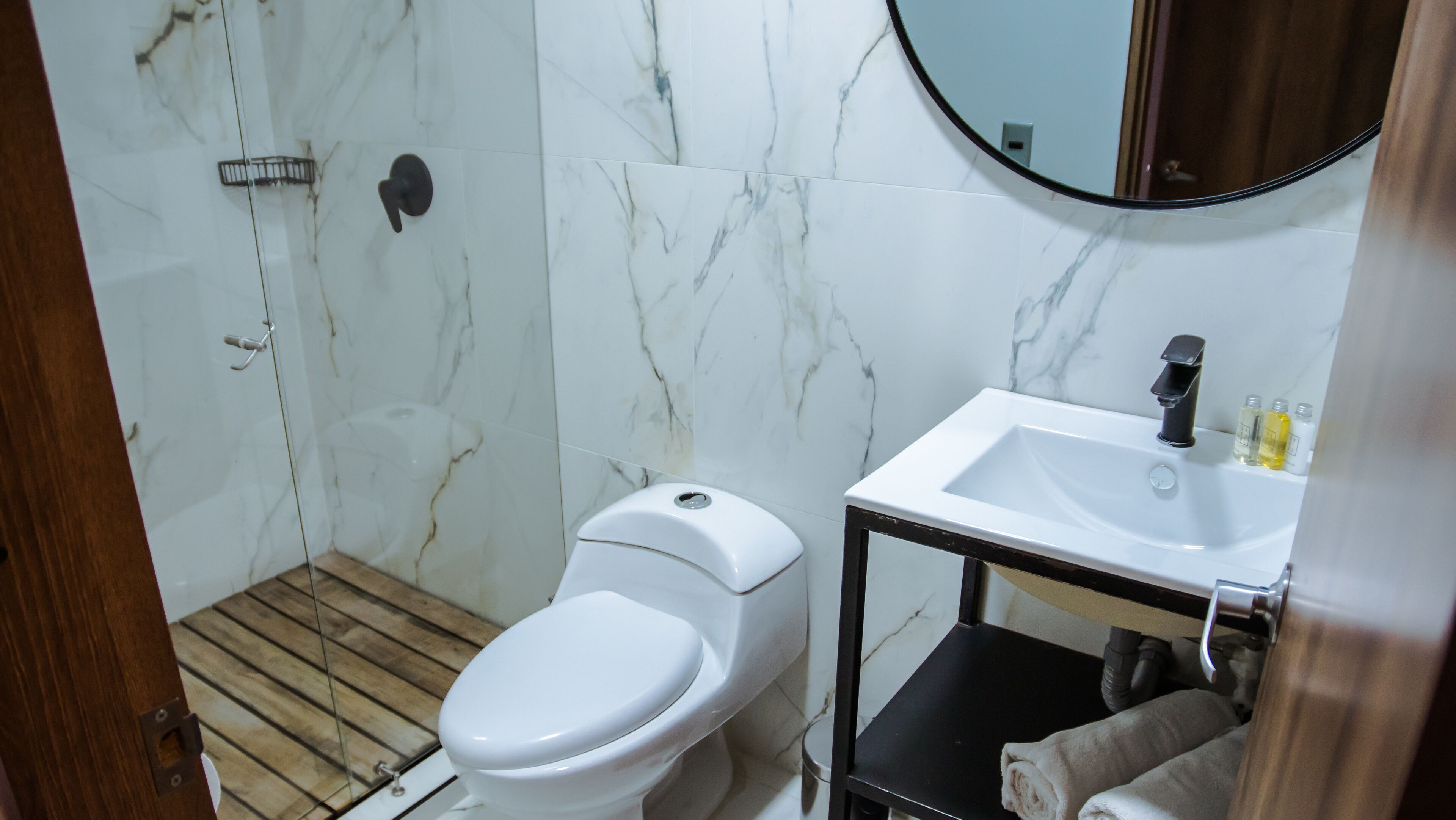 A bathroom with a toilet, a sink, and a shower area.