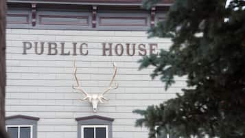 A building with a sign that reads "PUBLIC HOUSE" and a mounted deer skull above the entrance.