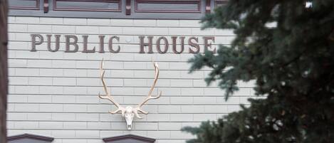 Edifici amb un rètol que diu "PUBLIC HOUSE" i un crani de cérvol muntat sobre l'entrada.