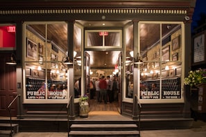 Un pub au décor intérieur en bois, avec un bar et des tableaux encadrés aux murs.