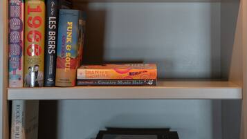 A bookshelf with books, a bottle, and a decorative object.