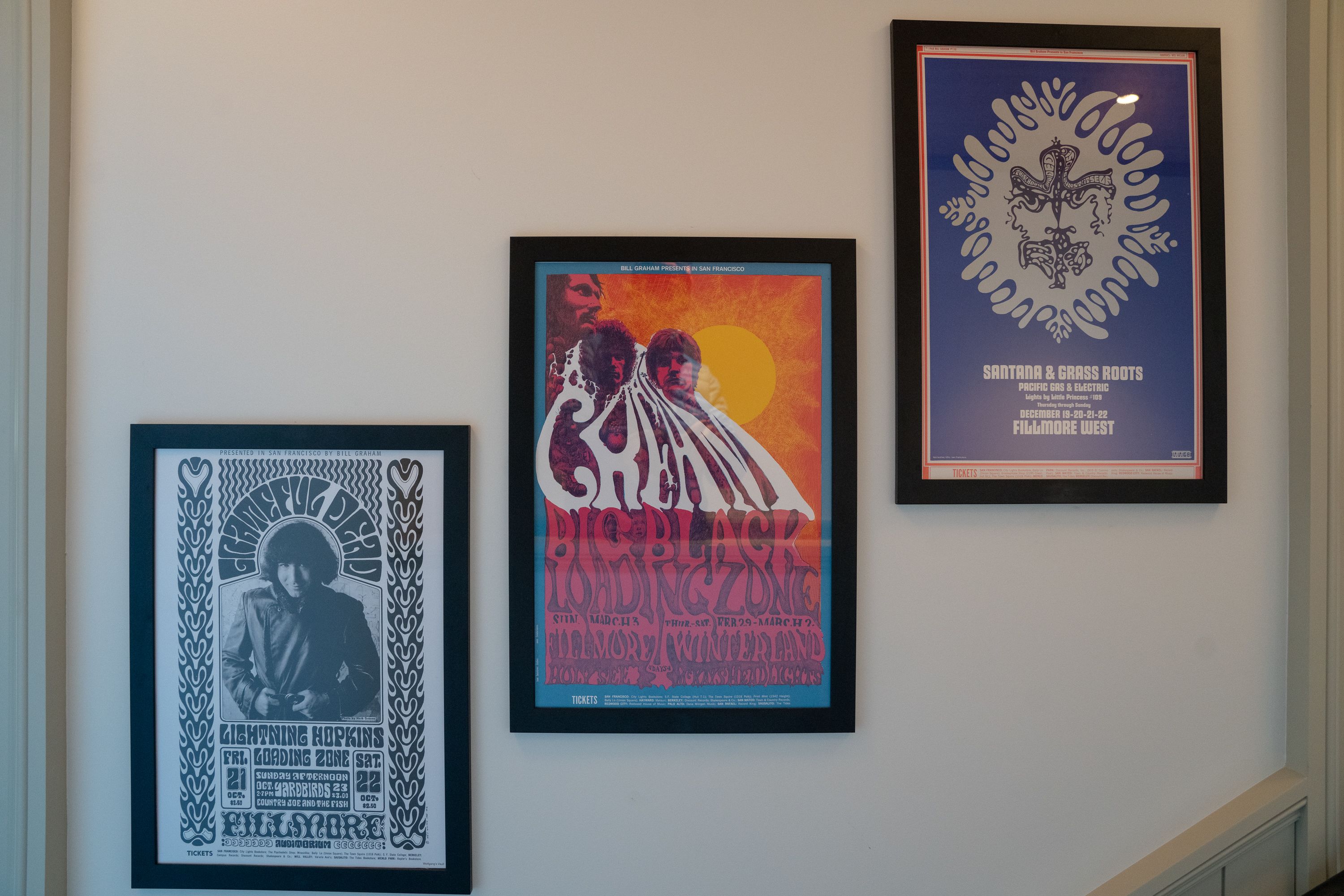 Trois affiches encadrées sont accrochées au mur.