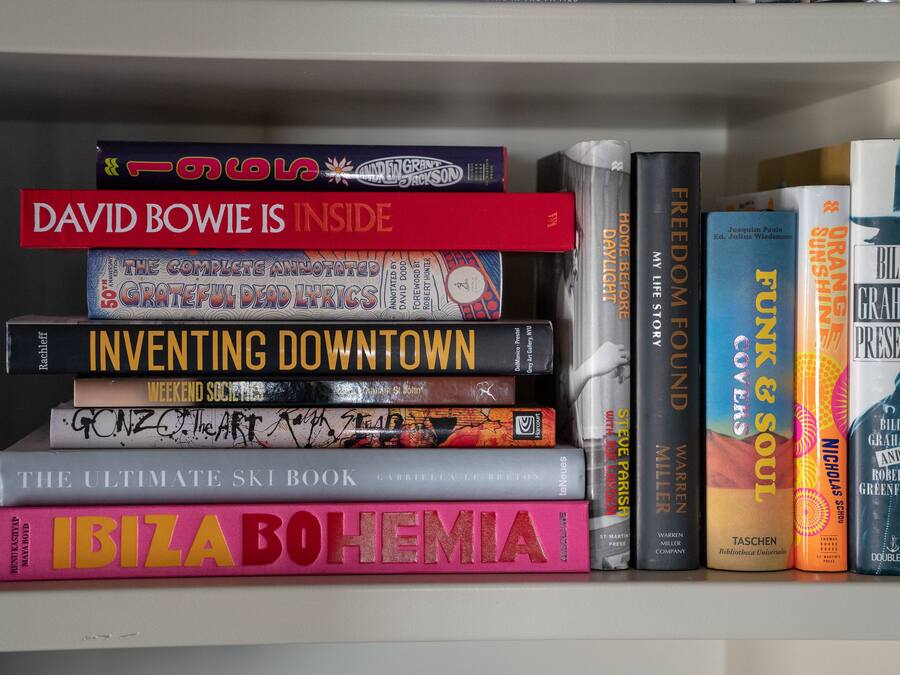 A bookshelf with various books, including titles like "David Bowie Is Inside" and "Inventing Downtown."