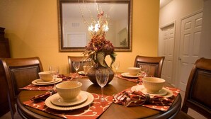 A dining table set with bowls, wine glasses, and a decorative centerpiece. - Vista Cay Homes by Atlas VH (Orlando)