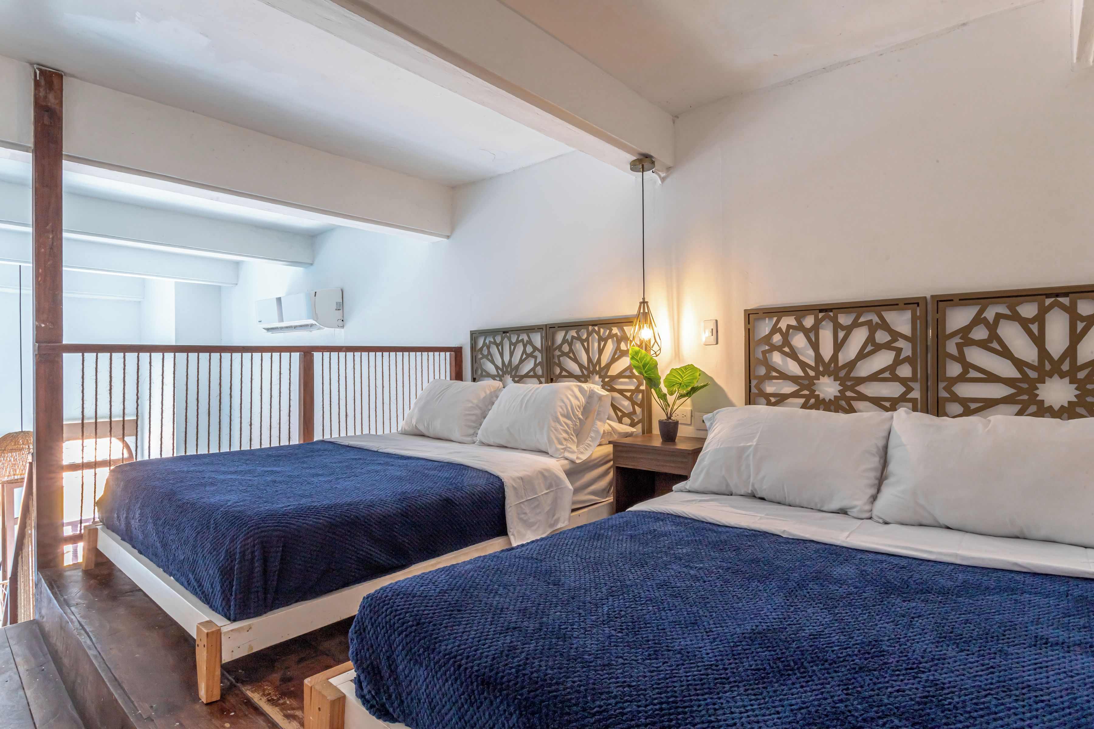 A hotel room with two beds, a balcony, and a decorative wall panel.