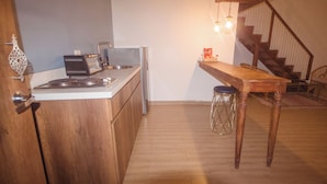 Una cocina con armarios de madera, una encimera, un tostador y una mesa con taburetes.