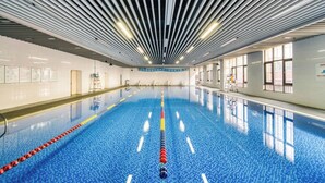 An indoor swimming pool with a blue tiled floor, white walls, and a ceiling with parallel lines. - Holiday Inn Hangzhou Airport Zone by IHG (Hangzhou)
