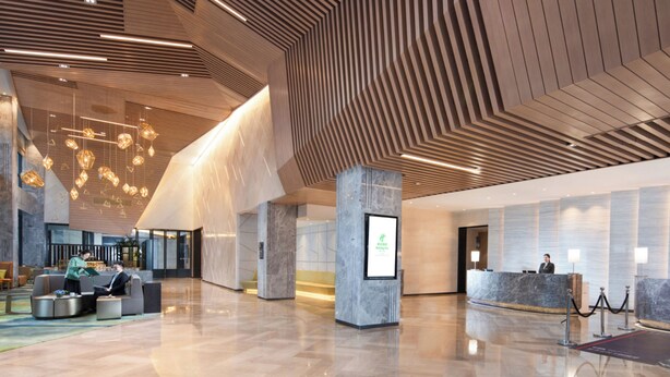 A spacious lobby with a modern design, featuring a reception desk, seating area, and a large digital display. - Holiday Inn Hangzhou Airport Zone by IHG (Hangzhou)