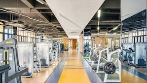 A gym with various exercise machines, a central walking path, and large windows allowing natural light. - Holiday Inn Hangzhou Airport Zone by IHG (Hangzhou)