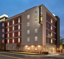 Un moderno edificio de hotel con un letrero que indica que es un Home2 Suites by Hilton.