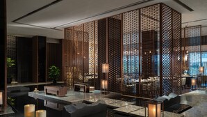 A modern interior with a water feature, seating areas, and a decorative partition. - Beijing Marriott Hotel Changping (Changping)