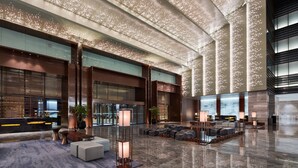 A spacious lobby with a high ceiling, modern furnishings, and a large seating area. - Beijing Marriott Hotel Changping (Changping)