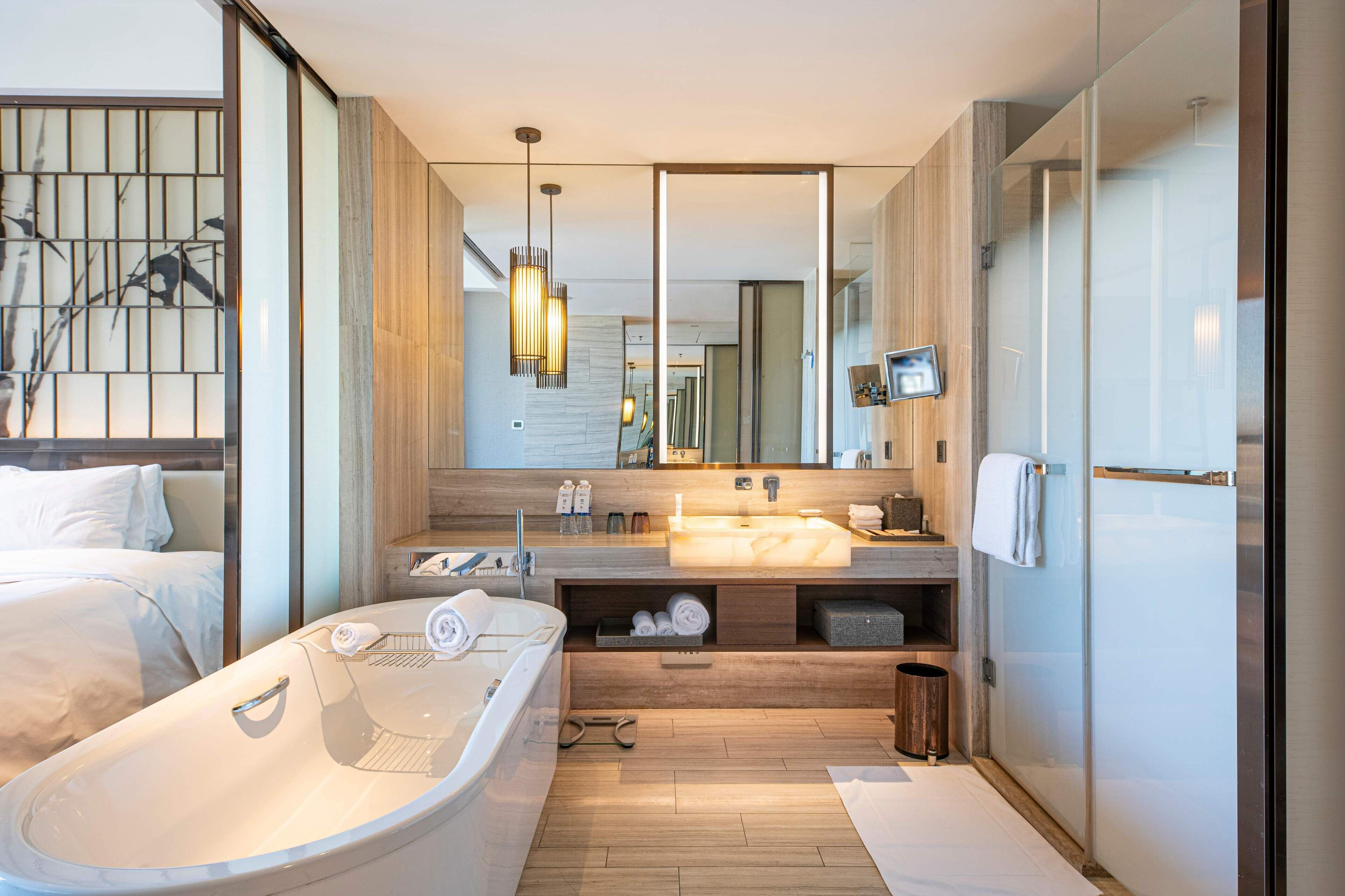 Un baño moderno con una bañera grande, un tocador con espejo y una zona de ducha.