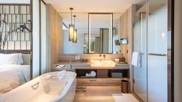 Un baño moderno con una bañera grande, un tocador con espejo y una zona de ducha.