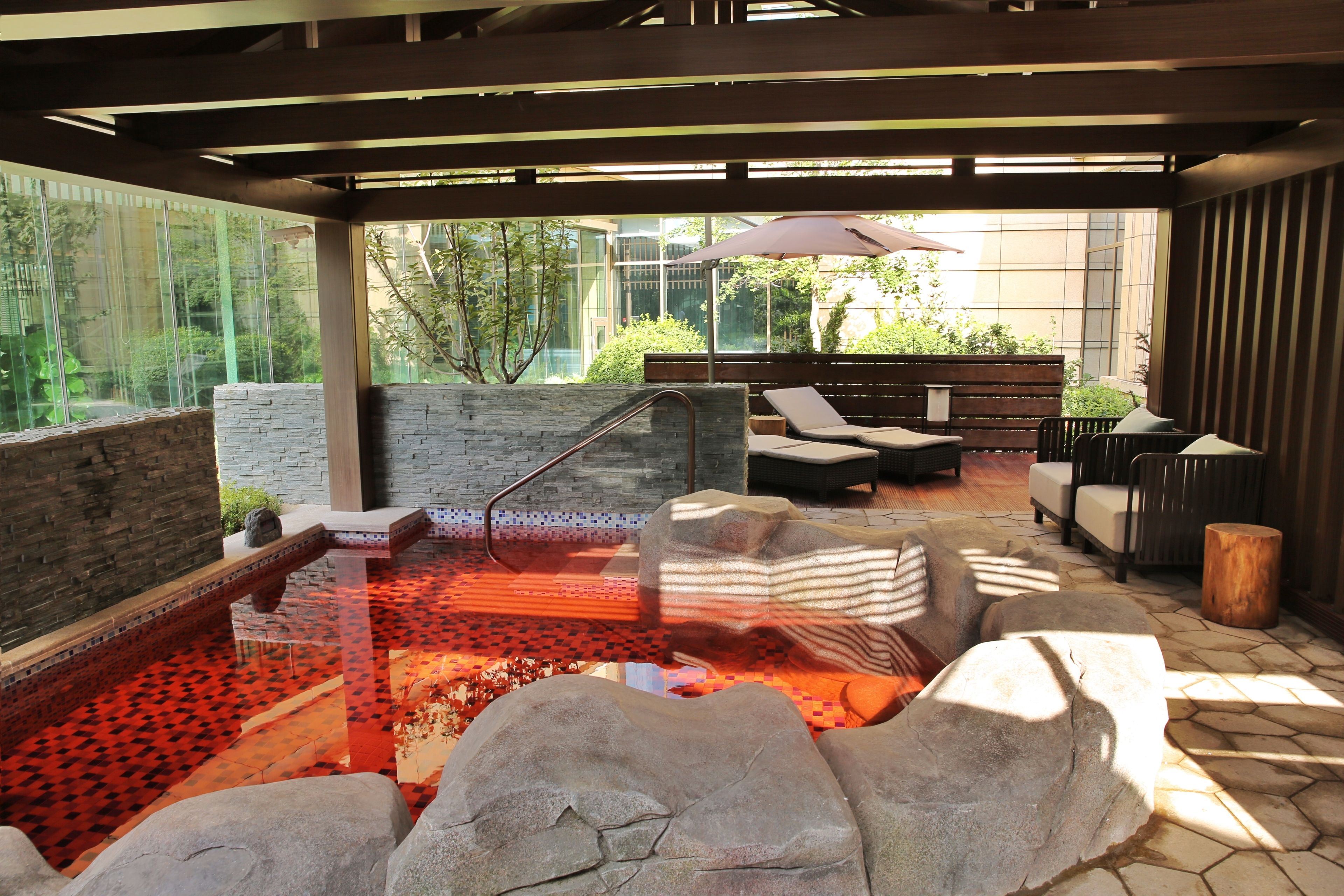 A spa area with a hot tub, seating, and a view of the outdoors.