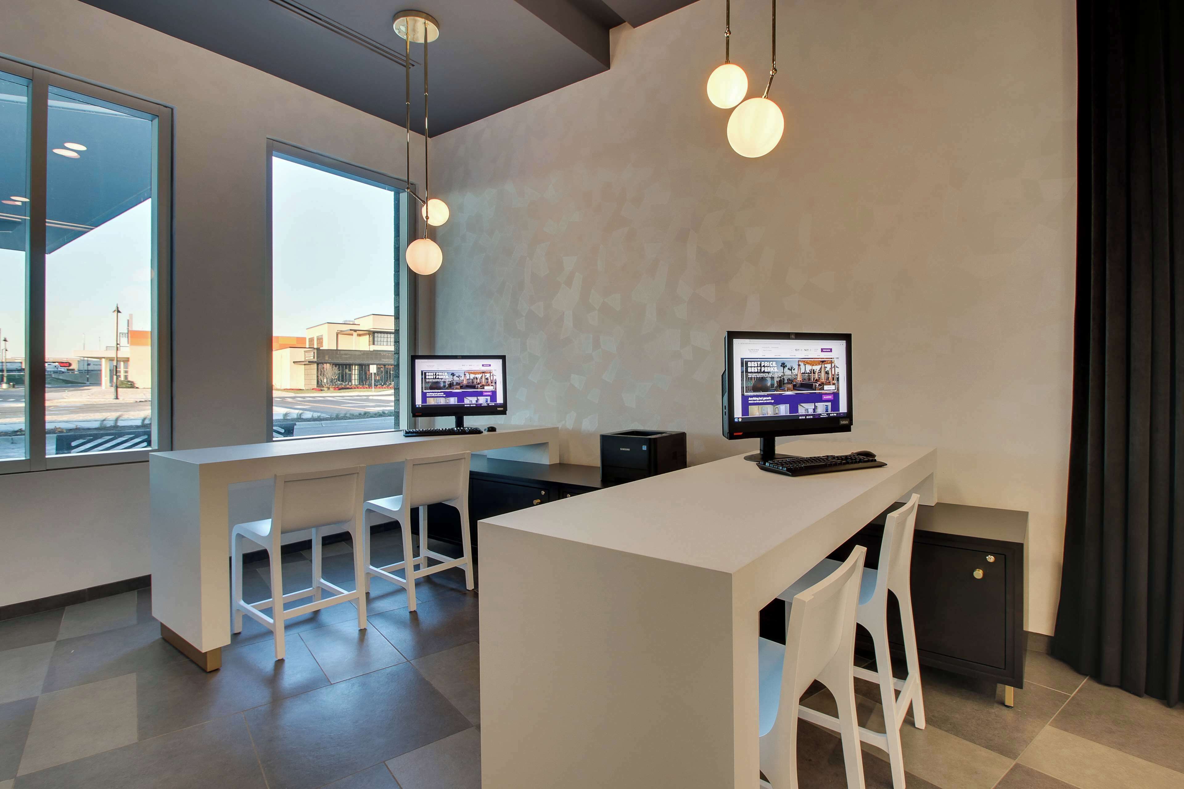 Un espace de bureau moderne comprenant deux bureaux, des chaises et des ordinateurs.