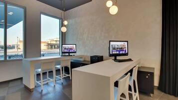 Un espace de bureau moderne comprenant deux bureaux, des chaises et des ordinateurs.