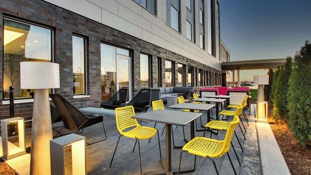 Een terras met tafels, stoelen en een bank, en een lantaarnpaal.