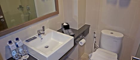 Un baño moderno con un lavamanos grande, inodoro y ducha.