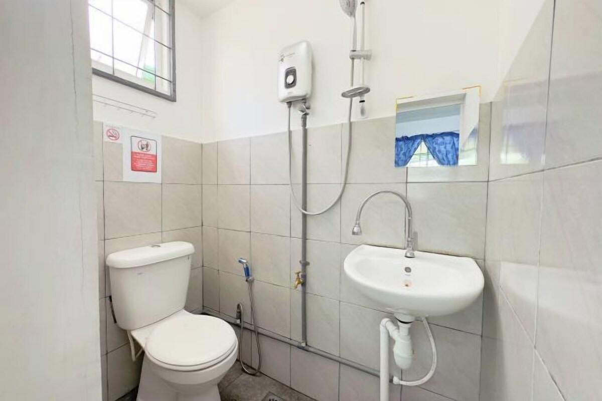 Een badkamer met toilet, wastafel, douche en raam.