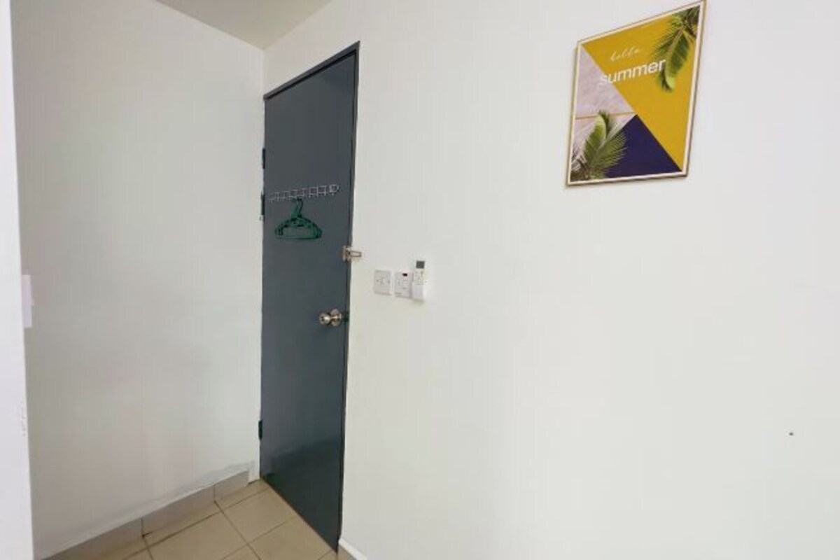 Un pasillo con una puerta cerrada, un interruptor de luz en la pared y un cartel con palmeras y el texto 'little summer'.