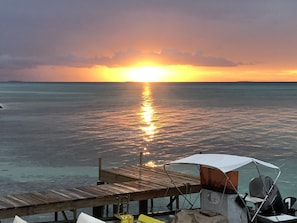 A wooden pier extending into calm waters with a sunset in the background. - Hakamanu Lodge (Tikehau)