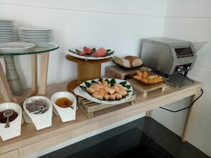 A buffet setup with various food items and a grill. - Bay Window at Sea (Cha-am)