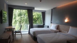 A hotel room with two beds, a desk, and a chair. - Bay Window at Sea (Cha-am)