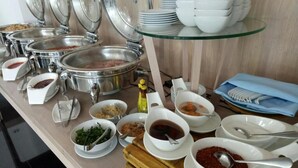 A buffet setup with various food items and serving utensils. - Bay Window at Sea (Cha-am)
