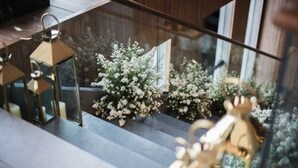 Un intérieur moderne avec une balustrade en verre, un plancher en bois et des lanternes décoratives.