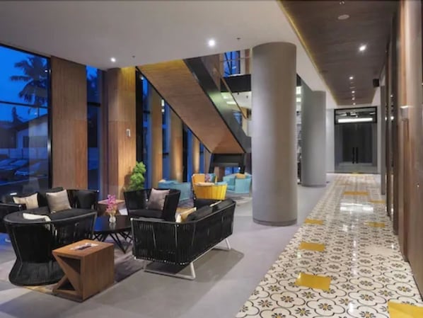 Un lobby moderno con zona de estar, ventanas amplias y suelo estampado.