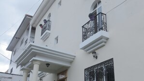 A white building with balconies, columns, and decorative iron railings. - Les Flamants Rose - Gulfview (Yaoundé)