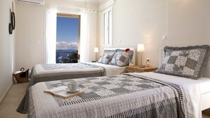 A hotel room with two beds, a view of the sea, and a balcony. - Violitzis Villas (Lefkada)