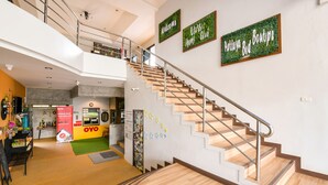 A modern interior with a staircase, a reception area, and a sign for 'Pattaya Bed Boutique'. - OYO 145 Pattaya Bed Boutique (Pattaya)