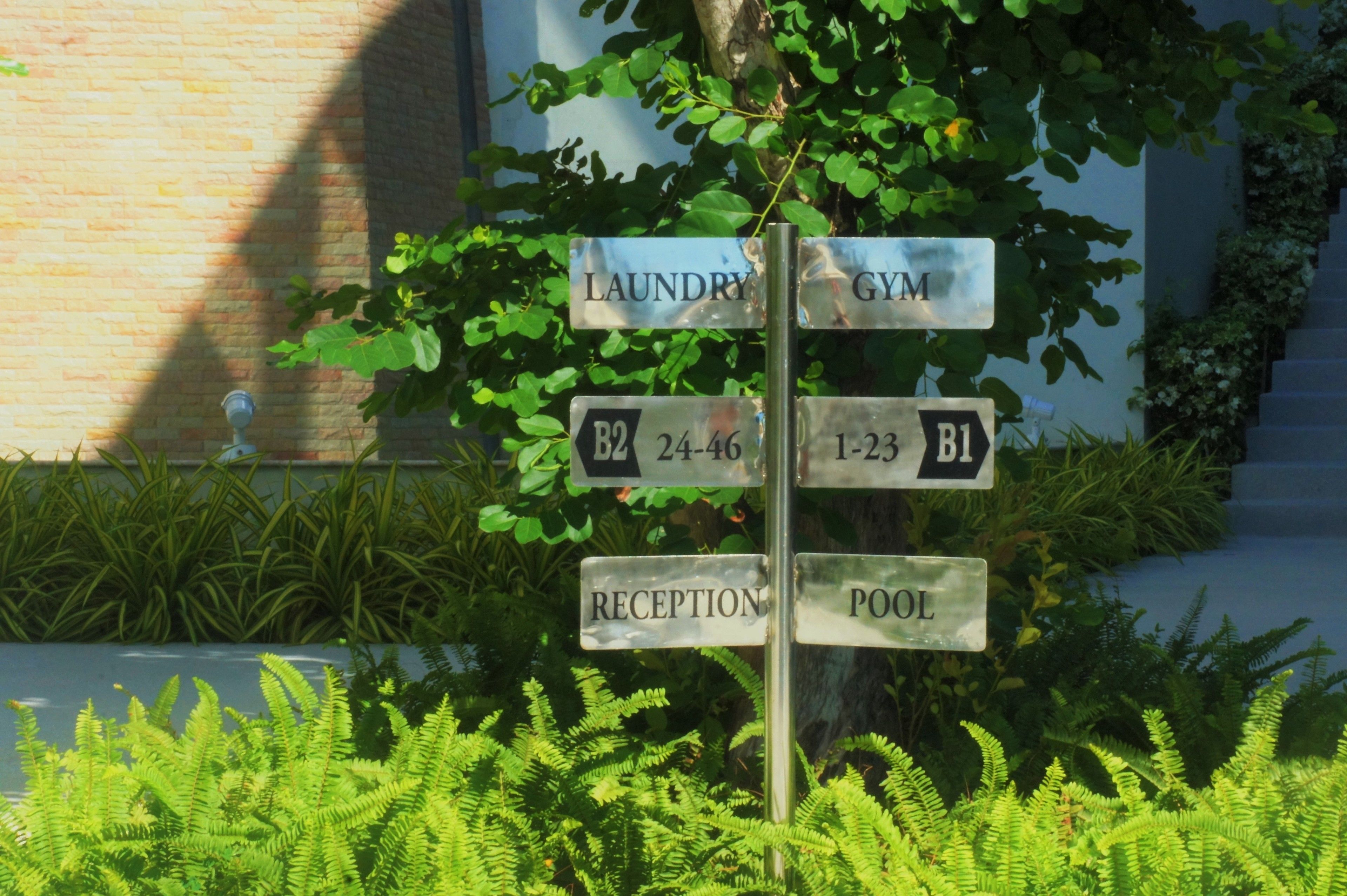 A directional signpost with labels for laundry, gym, reception, and pool.